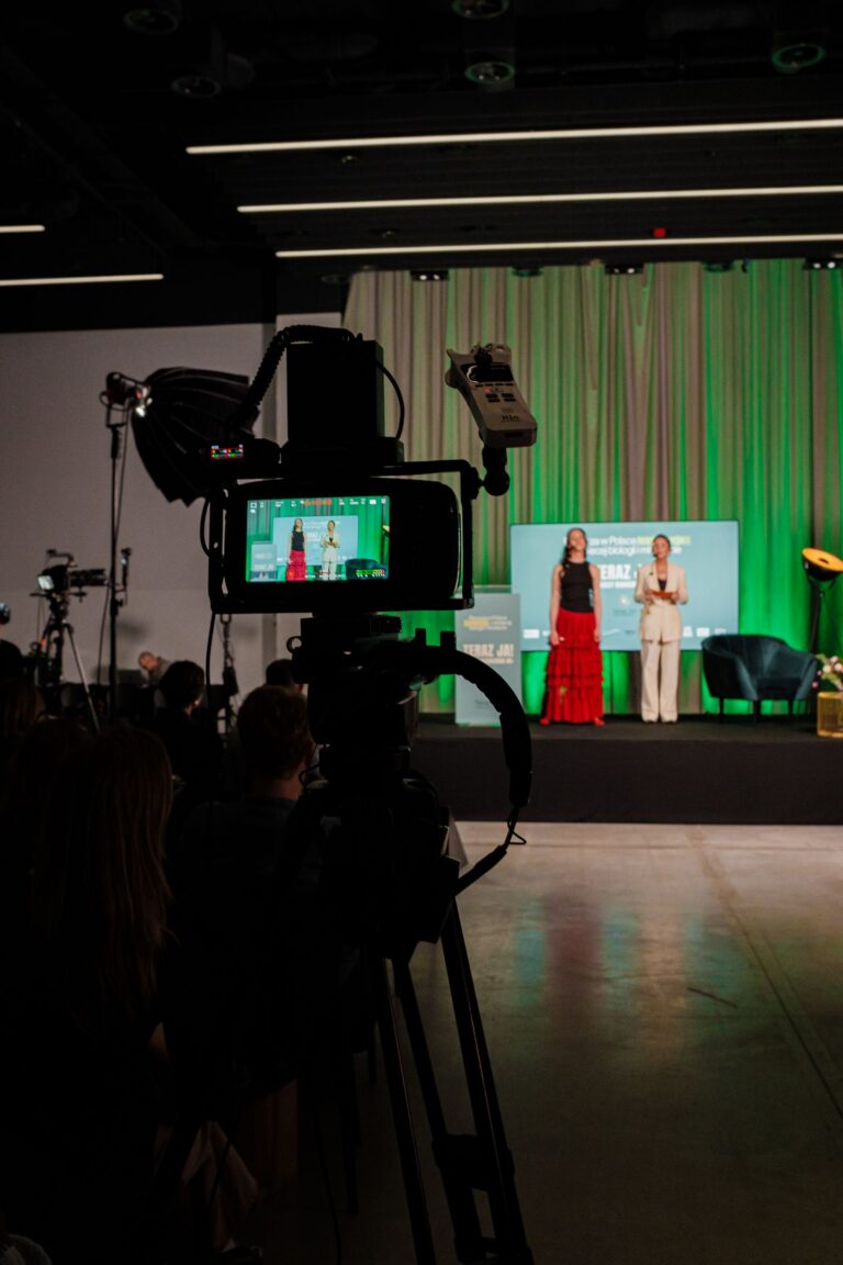 Kamera nagrywająca wystąpienie na scenie konferencji